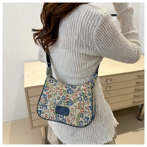 Vintage floral jacquard tote bag with blue trim and shoulder strap in a home setting