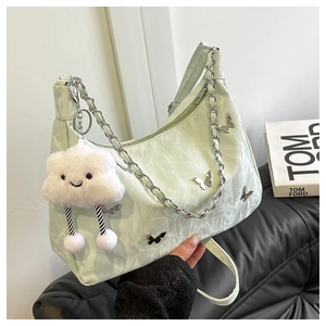 Détail du sac sous le bras vert clair plissé avec papillons et bijou nuage