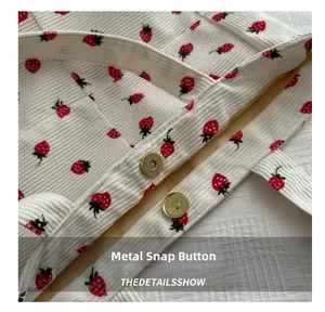 Detailed view of white corduroy tote bag with strawberry print and gold magnetic snap