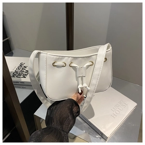Detailed view of the white PU leather shoulder bag featuring drawstring design and gold eyelets