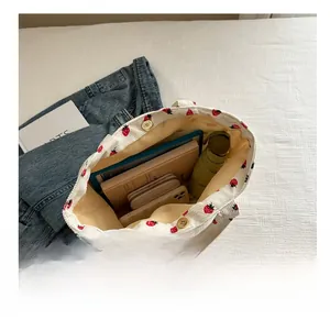Detail of large white strawberry corduroy tote bag showing interior storage capacity