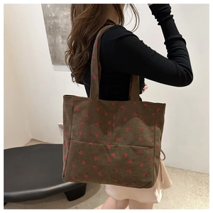 Sac fourre-tout en velours côtelé marron à motifs fraises porté par un mannequin en détail