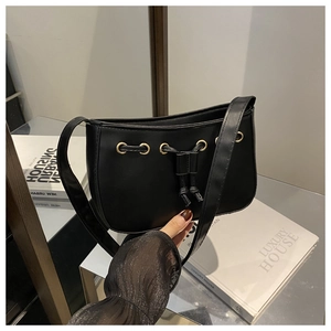 Close-up of black PU leather shoulder bag featuring gold eyelets and drawstring detail
