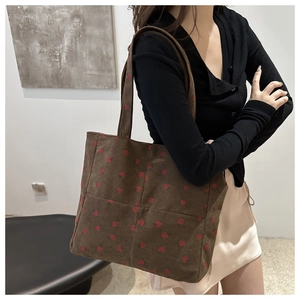 Gros plan d'un sac cabas marron en velours côtelé avec motifs de cœurs rouges