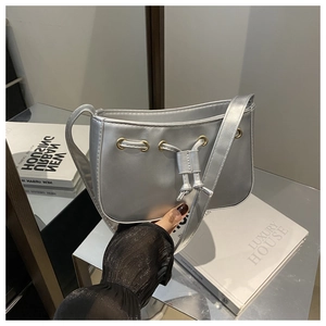 Metallic silver shoulder bag detail with drawstring design and gold eyelet accents