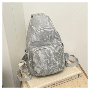 Detail of silver pleated fabric and metallic zippers on this compact crossbody chest bag