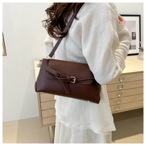 Detail of vintage brown rectangular crossbody bag with stylish knot buckle decoration