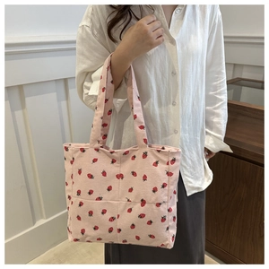 Détail du sac cabas en velours côtelé rose avec motifs fraises rouges et texture