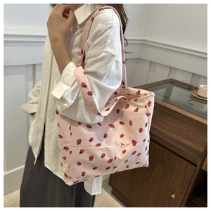 Détail du sac fourre-tout en velours côtelé rose avec imprimé fraise et bandoulière