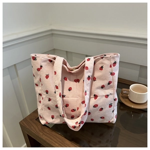 Détail du sac cabas en velours côtelé rose avec motif fraise et fermoir magnétique