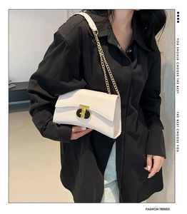 Détail du sac carré en cuir blanc crème avec fermoir en T doré et bandoulière chaîne
