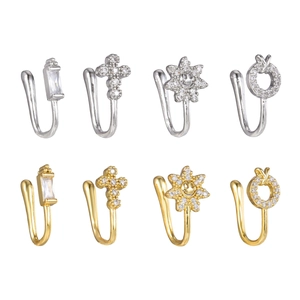 Dettaglio di 8 finti piercing per naso a forma di U con zirconi a sole e croce