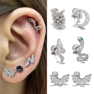 Detailed view of silver angel wings and snake stud earrings set with zircon stones