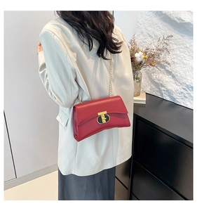 Détail du sac bandoulière carré rouge avec chaîne dorée et fermoir métallique en forme de T