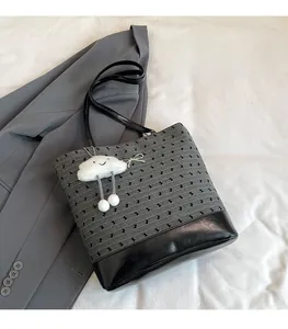 Detail of grey polka dot tote bag with cute cloud plush charm and black leather straps