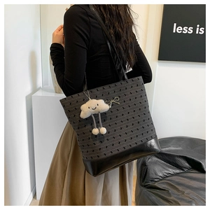 Polka dot tote bag detail featuring a metal bow and a cute white cloud plush pendant