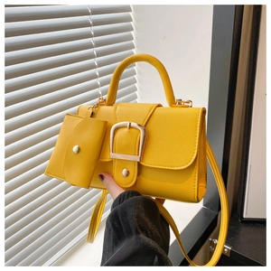 Detail of bright yellow crossbody bag with gold buckle and matching mini coin purse