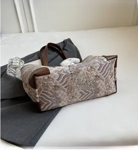 Detail of vintage wave pattern fabric and brown leather handle on large tote bag