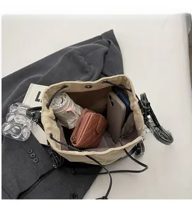 Interior view of beige canvas bucket bag showing large capacity for phone and umbrella