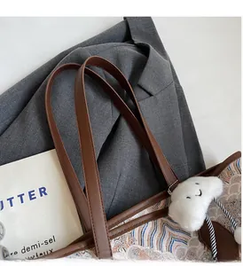Close-up of leather handles and jacquard pattern on a large capacity tote bag