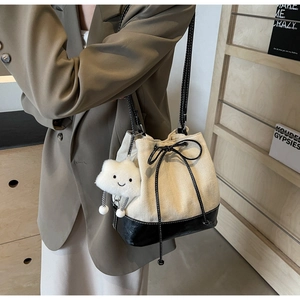 Chic beige canvas bucket bag with black leather trim and cute plush cloud charm