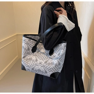 Stylish tote bag with black and white wave pattern and reinforced leather corners