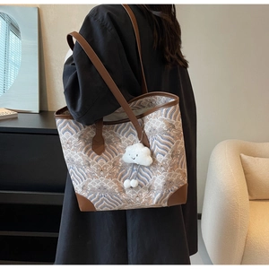Détail du sac cabas à motif vagues bleues avec anses en cuir et pendentif nuage