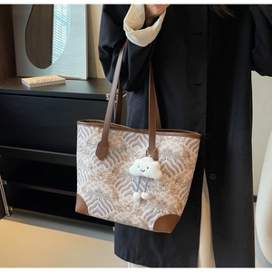 Détail du grand sac cabas avec motif de vagues, finitions cuir et charme nuage