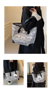 Detail of artistic black and white wave pattern tote bag with plush cloud charm