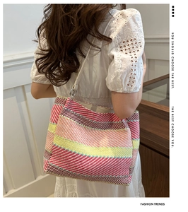 Détail d'un sac cabas tissé à rayures colorées avec bandoulière et anneau en métal