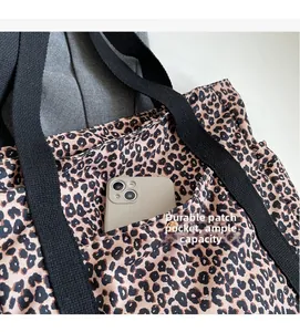 Detail of leopard print canvas tote bag with front pocket showing large capacity space