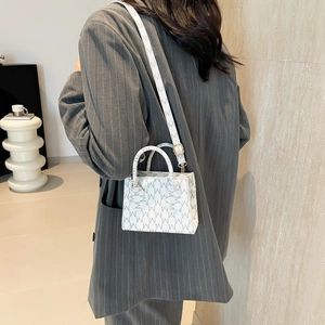 Chic mini square handbag with M-pattern print and gold hardware on female model