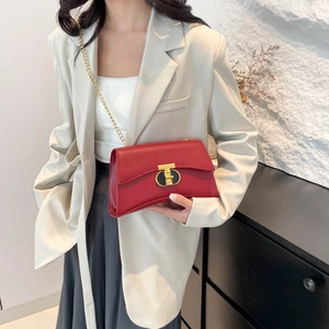 Sac bandoulière chic en cuir rouge avec fermoir T doré et chaîne sur un modèle élégant