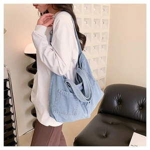 Large denim tote bag for women with a functional front pocket and wide shoulder strap