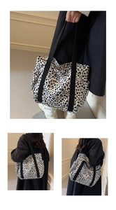 Detail view of large leopard print canvas tote bag with reinforced black shoulder straps