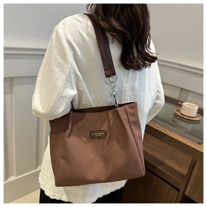 Brown large capacity PU tote bag with leather straps shown in a lifestyle setting