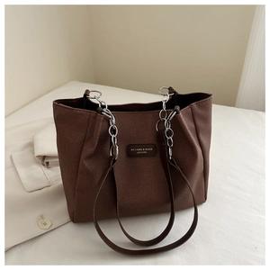 Detail of coffee brown tote bag showing fabric texture and silver chain strap
