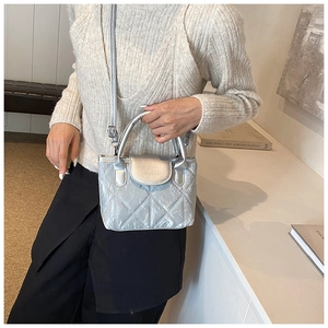 Silver quilted bucket bag with metallic finish shown on model with shoulder strap