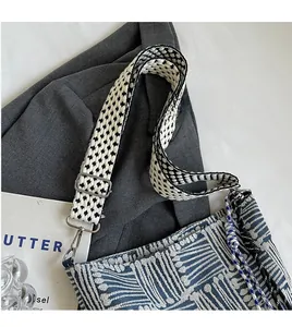 Detail of adjustable star-patterned strap and blue jacquard texture with colorful tassels
