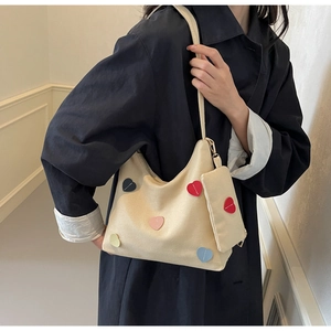 Detail of canvas tote bag with colorful heart patches and matching small square coin purse