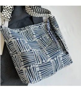 Close-up of blue geometric striped canvas tote with woven shoulder strap detail