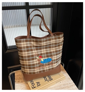 Detail of vintage plaid canvas bag with cute dachshund embroidery and leather handles