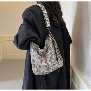 Detail of striped canvas tote bag with jacquard texture and braided rope tassels