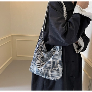 Detail of blue and white geometric woven hobo bag showing thick fiber texture and silver hooks