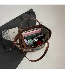 Spacious interior of brown checkered tote bag showing iPad, umbrella and daily essentials