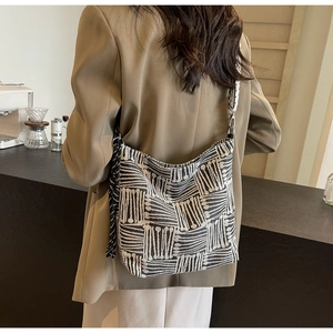 Striped canvas tote bag with black shoulder strap and tassel detail for women