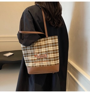 Detail of canvas tote bag featuring brown plaid pattern and dachshund embroidery