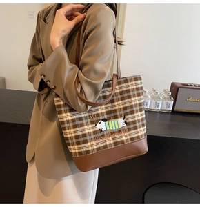 Detail of checkered tote bag with puppy embroidery and vintage brown leather panels