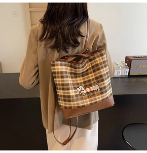 Detail of plaid canvas tote with cartoon dog embroidery and brown leather base