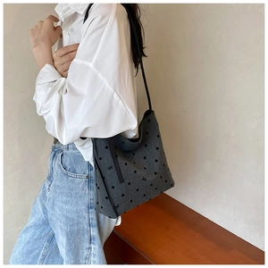 Detail of grey canvas tote bag with black polka dots and embroidered ribbon bows